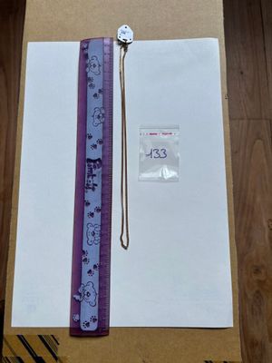 une règle violette posée sur une feuille de papier, à côté d'une autre règle