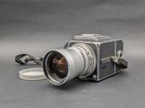 a camera with a lens attached to it on a gray surface