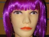 une tête de mannequin aux cheveux violets et au rouge à lèvres orange
