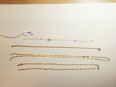 a lot of gold necklaces and bracelets laid out on a table