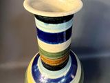 a vase that is sitting on a stand on a table