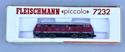 a red and black train on display in a white box