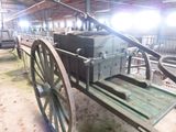 a horse drawn carriage with a wooden seat in a barn