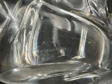 a close up of a clear glass vase with a bird on it