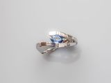a close up of a silver ring with a blue topaz stone