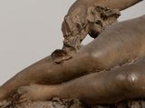 statue of a woman laying down on a rock with her hands on her stomach