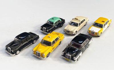 plusieurs petites voitures sont alignées sur une surface blanche
