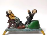 une figurine représentant deux personnes assises sur un banc
