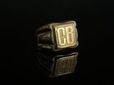 un gros plan d'une bague en or sur laquelle est gravé « cb »