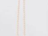 un collier de perles blanches sur fond blanc