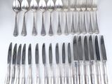 beaucoup de cuillères et de couteaux en argent sur la table
