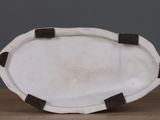 a white plate with black trims on a wooden table