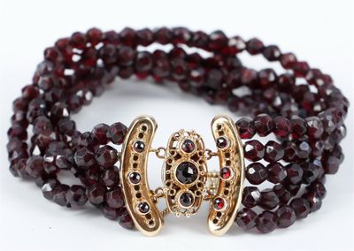 un gros plan d'un bracelet orné de grenats