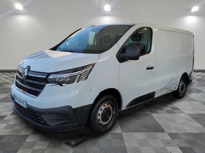 Une camionnette blanche est garée dans une pièce au sol carrelé en damier.