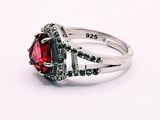 a ring with a red stone surrounded by black diamonds