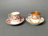 two cups and saucers are sitting on a table