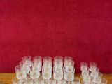 de nombreux verres posés sur une table, avec un mur rouge en arrière-plan