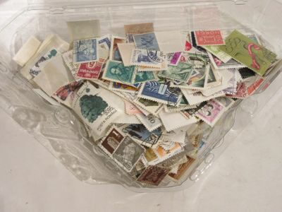 un récipient en plastique rempli de timbres-poste posé sur une table