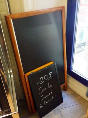 un tableau noir sur lequel est inscrit un prix, devant une vitrine