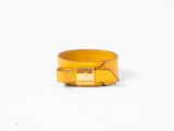 un gros plan d'un bracelet jaune sur fond blanc