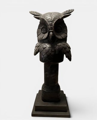 sculpture of an owl on a pedestal on a white background