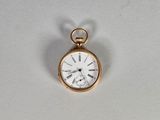 une petite montre de poche en or avec des chiffres romains