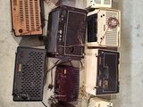 a lot of old radio ' s sitting on the floor