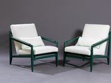 pair of green and white lounge chairs against a gray wall