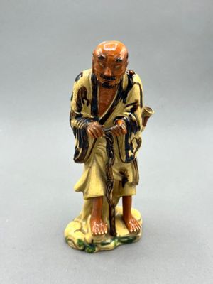 an image of a figurine of an old man with a cane