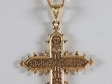 a gold cross pendant with a chain on a white background