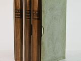 three books sitting on top of a white table next to each other