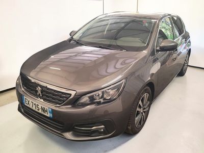 La voiture grise est garée dans une grande pièce au sol blanc.