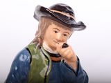 a figurine of a man wearing a hat and holding a cell phone to his ear