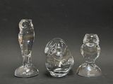 trois figurines en verre posées sur une table
