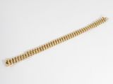 gros plan d'un bracelet en or sur une surface blanche