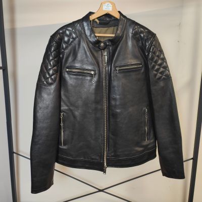 une veste en cuir noir accrochée à un porte-manteau dans une pièce