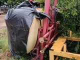un tracteur qui est garé dans l'herbe, avec un sac posé dessus