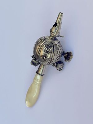 a small silver object on a white surface