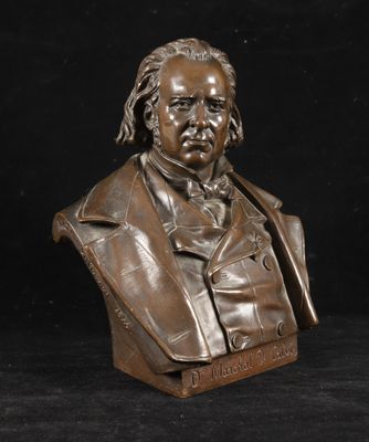 un buste en bronze représentant un homme en costume-cravate