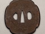 an old iron tsubai with two holes in the middle of it