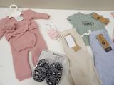 many baby clothes and shoes on a table