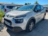 une Citroën argentée garée sur un parking à côté d'autres voitures