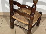 a wooden chair with a woven seat on a tiled floor