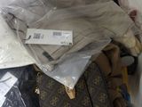 a pile of clothes and a suitcase on the floor