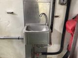 un lavabo dans un coin d'une pièce au sol vert