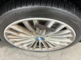 tire of a black car with a white rim and a blue sticker on it