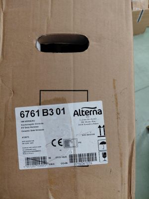 une boîte sur laquelle est collé un autocollant, posée par terre