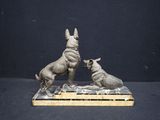 sculpture of two dogs playing with each other on a marble base