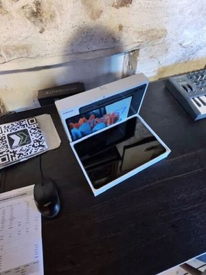 un ordinateur portable posé sur un bureau, avec un clavier à côté