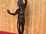 statue d'un homme tenant une raquette de tennis sur un fond rouge